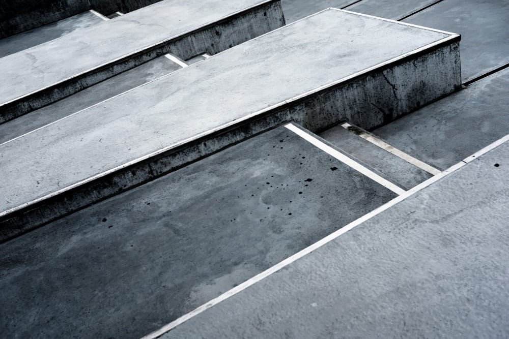 Monochromatic concrete slabs overlap in a geometric pattern, creating a modern, industrial aesthetic.